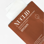 A close-up of a Nuclid Collagen Lifting Energy Elastic Mask package in brown, with a white sheet partially visible at the top on a clean white background.