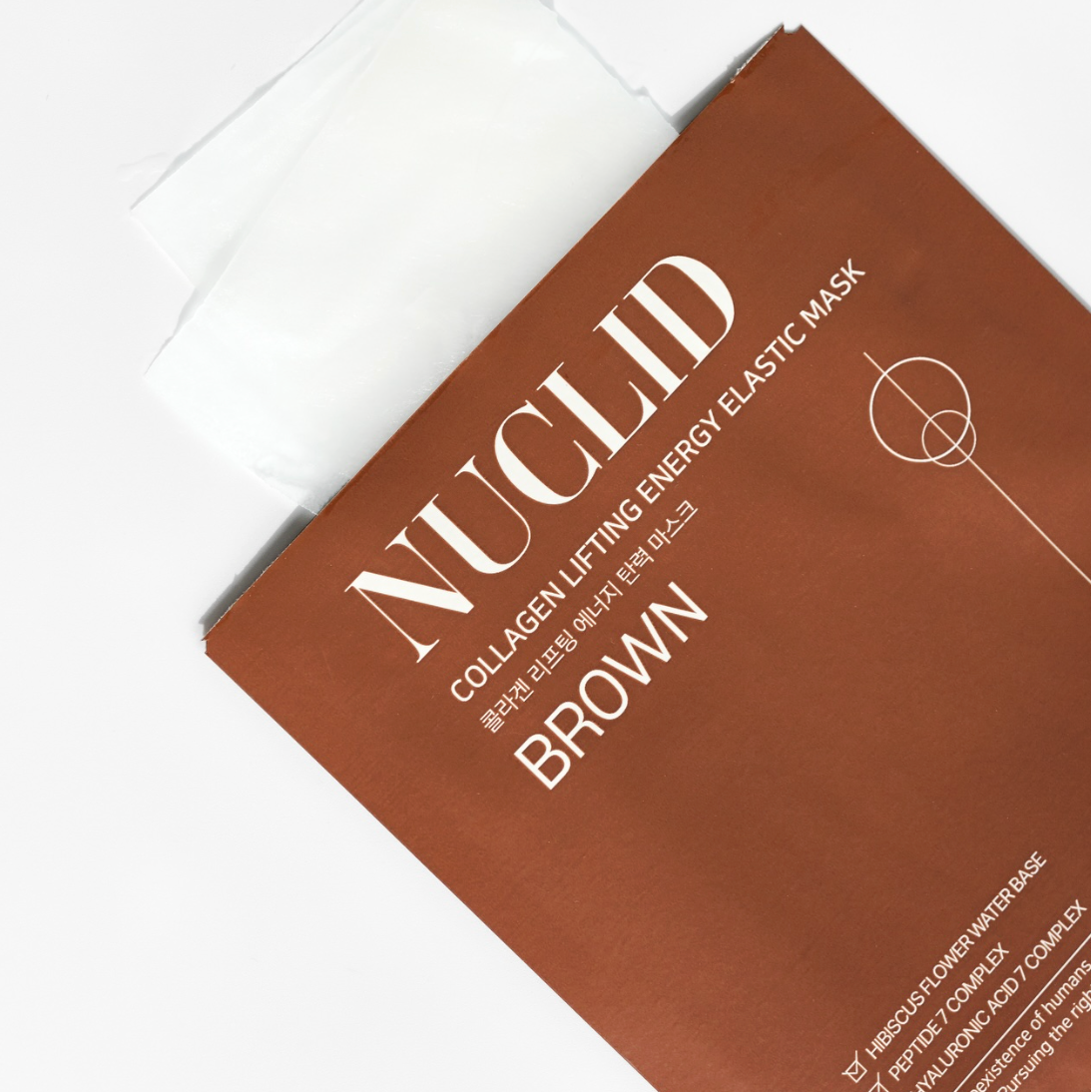 A close-up of a Nuclid Collagen Lifting Energy Elastic Mask package in brown, with a white sheet partially visible at the top on a clean white background.