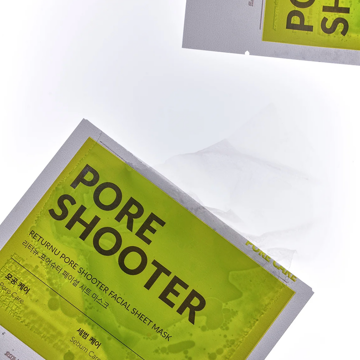 A close-up of a sheet mask package labeled 'PORE SHOOTER' with a translucent white sheet partially pulled from the top, on a clean white background.