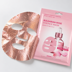 A rose gold metallic sheet mask next to its pink packaging pouch labeled 'BULGARIAN ROSE ESSENCE MASK' by Dermal Shop, on a clean white background.